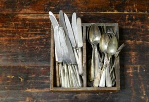 Collection of old vintage cutlery in a wooden tray